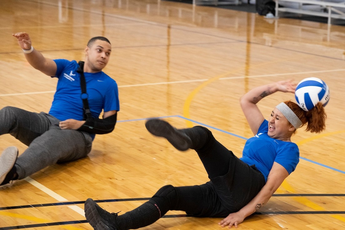 A female athlete prepares to hit a volleyball during training, embodying the spirit of adaptive sports.