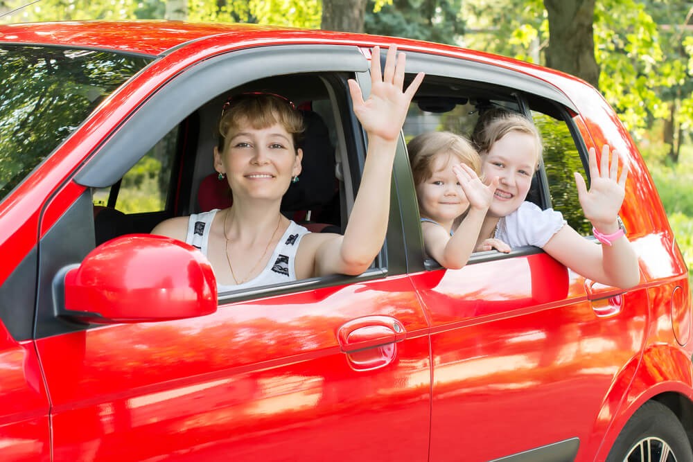 A happy mother and her children are enjoying their new free car.