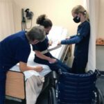 Experienced CNA instructor guides students in practical skills training, highlighting the benefits of a best care CNA program