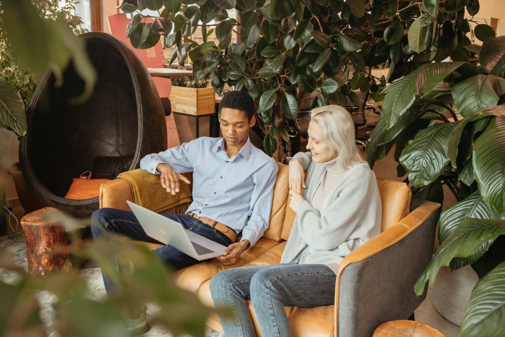 An older lady learning with a young man on a laptop