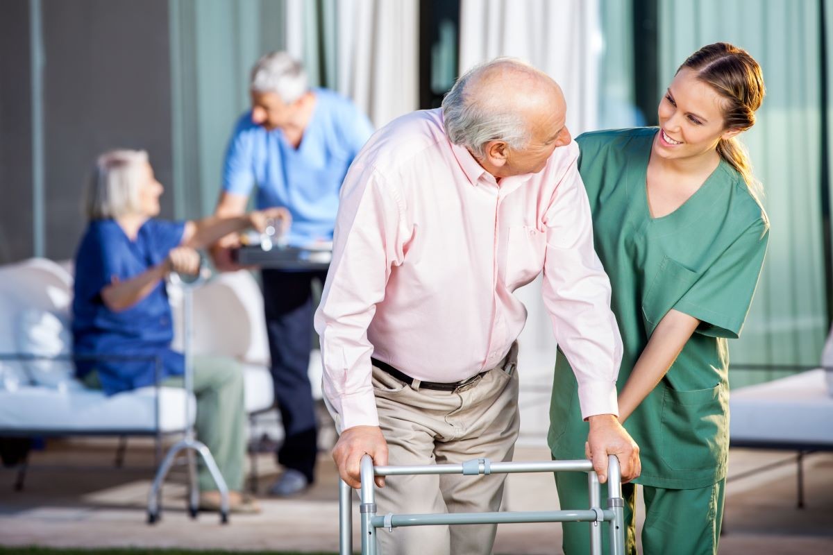 A nurse assists a senior resident with a walker, highlighting the importance of care in long-term facilities.