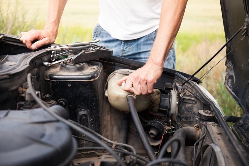 Location of the engine coolant temperature sensor in a car engine bay, highlighting its proximity to engine components.